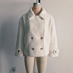 Detail of white sherpa coat featuring classic lapels and amber double-breasted buttons
