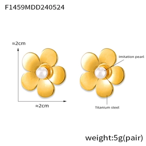 Vue détaillée des boucles d'oreilles fleur en acier titane plaqué or 18K et perles