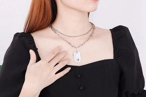 Detail of silver double layer necklace with square pendant and hollow heart design