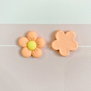 Close-up of pink matte resin flower charms showing front and back details for DIY crafts