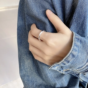 Close-up of a minimalist 925 sterling silver winding geometric ring worn on hand