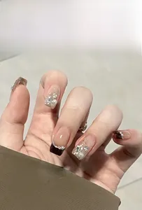 Detail of luxury press-on nails with silver glitter, burgundy finish, and pearl accents