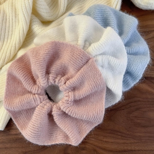 Chunky ruffled knit scrunchies in pink, white, and blue colors for autumn hairstyles