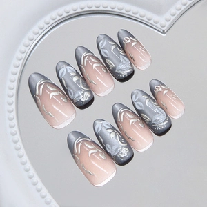 Cat eye press-on nails with silver floral relief on a heart mirror tray