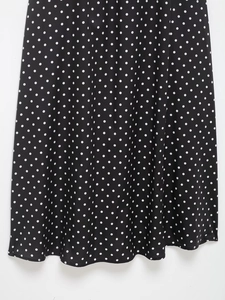 Detailaufnahme von weichem schwarzem Stoff mit weißen Punkten für das Kleid
