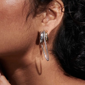 Detailed close-up view of titanium steel chunky hoop earrings with connecting silver chain