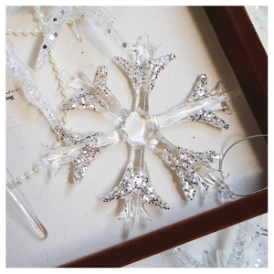 Detailed close-up of sparkling silver snowflake ornament with glitter and crystal details