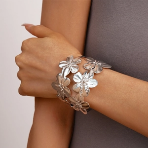 Detailed view of silver layered flower cuff bracelet with brushed metallic texture