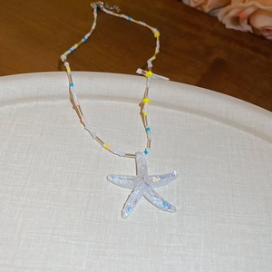 Detailed view of resin starfish pendant on a multi-colored seed bead beach necklace