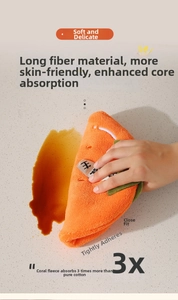 Macro shot of a carrot-shaped coral velvet towel absorbing spills on a stone countertop