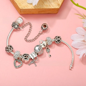 Detail of silver-plated snake chain bracelet with heart lock and key charms