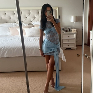 Detail of light blue lace cutout mini dress with flowing ribbon and hollow-out design