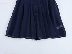 Detail of dark blue pleated sleeveless blouse featuring metallic button placket and soft chiffon