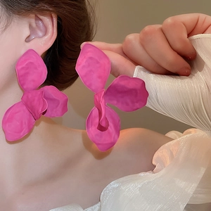 Detail of pink matte flower earrings showing large floral design and resin texture on model