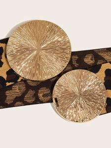 Detail of leopard print elastic belt with two gold round buckles and radial textures