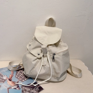 Front view of beige nylon backpack featuring plastic buckle and drawstring closure