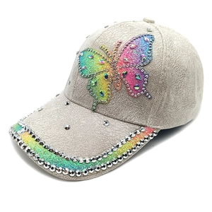 Close-up of suede baseball cap with colorful butterfly embroidery and sparkling rhinestones