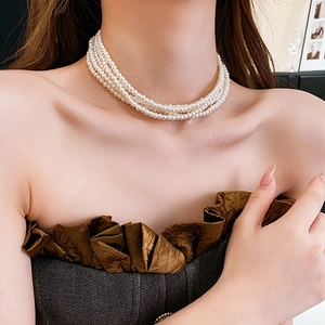 Detail einer eleganten vierlagigen weißen Perlen-Choker-Halskette am Modellhals