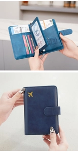 Detail of blue leather RFID passport wallet with card slots and metal plane logo