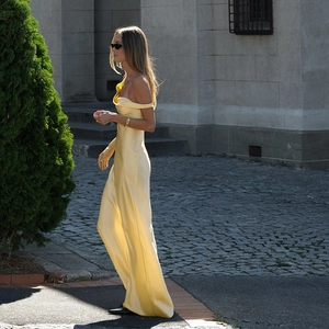 Gros plan sur une robe longue en satin jaune montrant la texture soyeuse et le dos nu