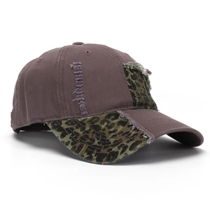 Detail of vintage brown baseball cap with leopard print patches and distressed frayed edges