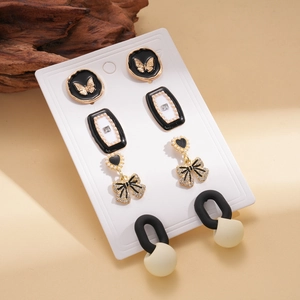 Eight-piece gold earring set with enamel butterfly, heart bow, and sparkling crystals