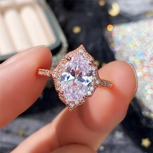 Rose gold engagement ring featuring an oval halo crystal and vintage filigree detailing