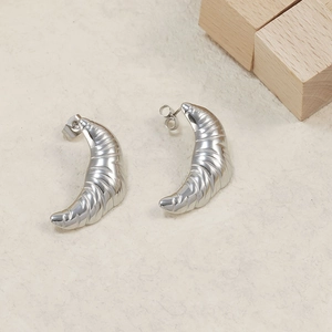 Detail of silver croissant dome earrings featuring a polished spiral textured finish