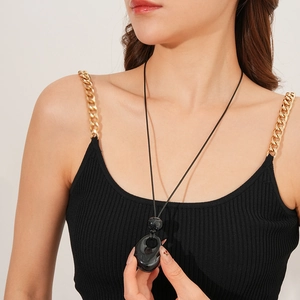 Detail of minimalist black drop pendant on a wax rope necklace worn by a model