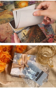 Macro view of vintage landscape oil painting paper pads and tied gift box packaging