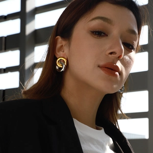 Close-up of interlocking gold and silver rings on model with dramatic shadow lighting