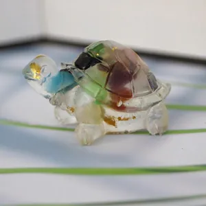 Close-up of resin turtle figurine with colorful crystal stones and gold foil flakes
