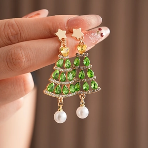 Detailed close-up of Christmas tree drop earrings with green rhinestones and white pearl