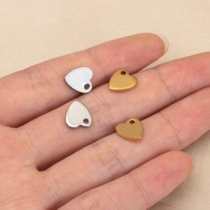 Polished heart pendants in gold and silver finish for DIY jewelry making shown on hand