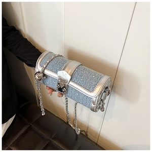 Detail of denim and silver leather cylinder bag featuring rhinestones and metal chain