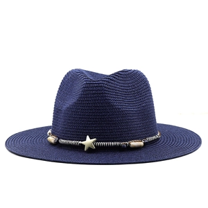 Detail of dark blue straw fedora hat with star ornament and woven beaded band decoration