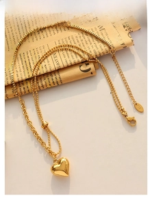 Detail of 18K gold-plated heart necklace with mixed chain link textures and lobster clasp