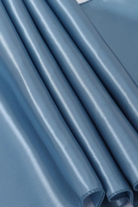 Close-up of blue satin table runner fabric showing smooth texture and elegant folds
