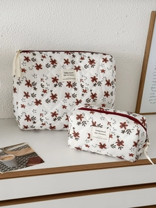 Detail view of quilted corduroy makeup bags set with orange floral patterns