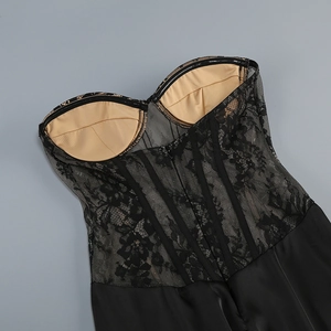Close-up of black floral lace corset top with sheer mesh, boning, and satin fabric details