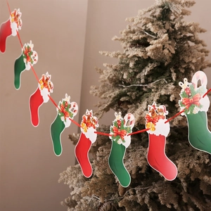 Detail of Christmas stocking paper banners with bear and bell accents on a tree