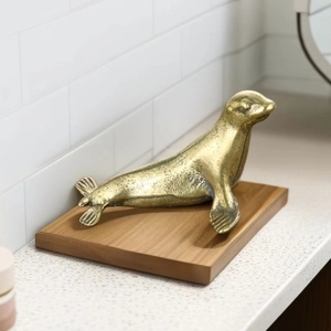Macro shot of vintage brass seal sculpture with textured finish on wood base