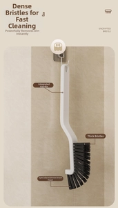 Hanging crevice cleaning brush with dense bristles on a bathroom marble wall