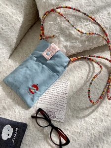 Cute denim crossbody bag with apple embroidery and checkered button on plush background