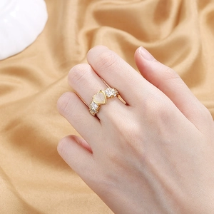 Elegant gold-tone adjustable heart opal ring with baguette side stones on satin