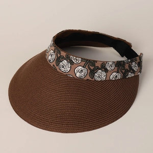 Close-up of brown straw sun visor with delicate white rose embroidery on the headband