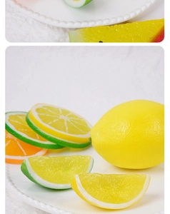 Detailed view of realistic PVC lemon and orange slices on a white decorative display plate