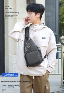 Detail view of a dark grey multifunctional crossbody chest bag with headphone port on male model