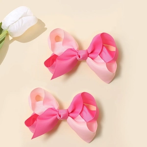 Détail de deux nœuds papillon bicolores rose en ruban de satin avec une texture de tissu doux