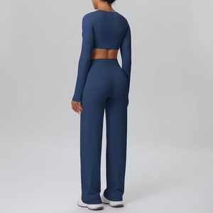 Rear view of tight long-sleeve crop top and high-waist wide-leg blue sports trousers